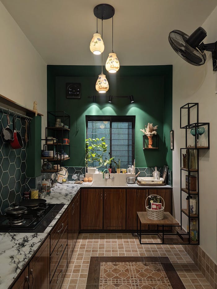 Cozy modern kitchen featuring marble countertops, wooden cabinets, and artistic lighting.